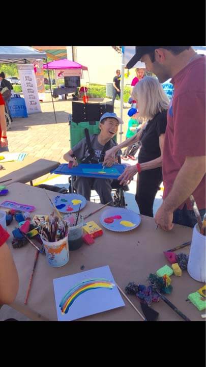 A man sitting at a table with some art supplies.