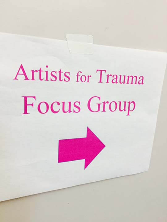 A sign that says artists for trauma focus group.